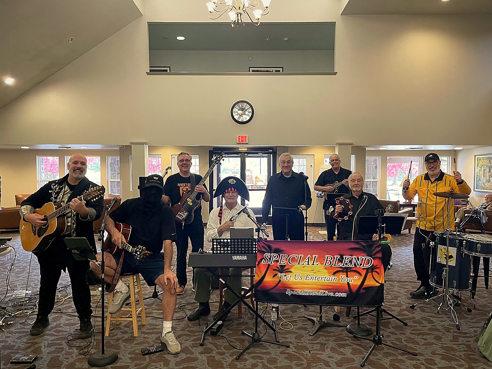 Special Blend full 7-piece band smiling together on stage with Brian on 12-string guitar